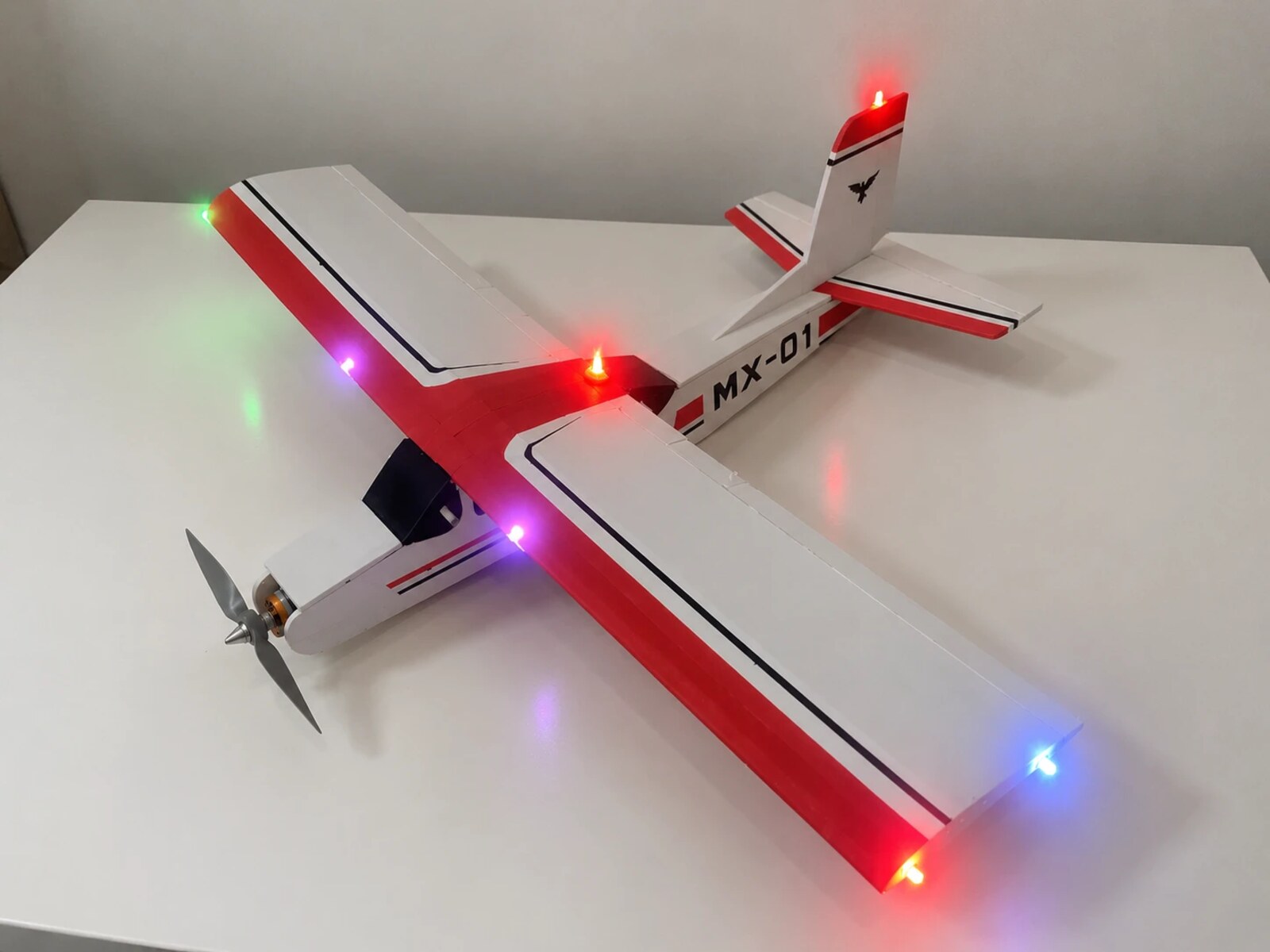 MX-01 on a table, with its red and white livery and navigation lights on